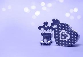 coffret cadeau et voiture rétro avec des coeurs en papier sur un fond très péri. concept de la saint-valentin, anniversaire, fête des mères et voeux de joyeux anniversaire, fond, gros plan photo