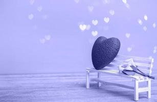 coeur rouge avec un bouquet de lys jaunes sur un banc blanc sur fond de bokeh très péri. concept d'amour, gros plan avec espace de copie. photo