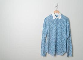 chemise suspendue avec cintre en bois au mur photo