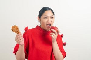 femme asiatique avec poulet frit et pomme à portée de main photo