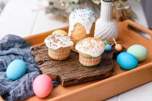 gâteaux de fête avec glaçage blanc, noix et raisins secs avec œufs de pâques sur la table de fête photo