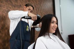 femme cliente ayant un processus de traitement d'un cheveu avec un coiffeur dans un salon de beauté photo