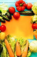 cadre de légumes avec papier de recette sur fond en bois bleu. vue de dessus photo