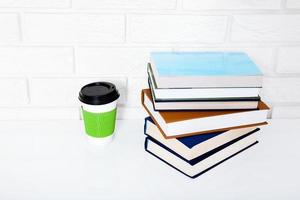 accessoires d'éducation. tasse de café et livres sur la table dans une classe. vue de dessus et espace de copie. mise au point sélective photo