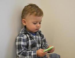 Beau petit garçon avec un photographe de pose de visage d'enfant photo