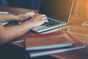 mains de jeune femme d'affaires tapant sur le clavier pour travailler au bureau. photo