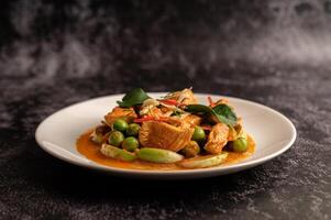 curry vert sec au poulet dans des assiettes blanches sur ciment noir photo