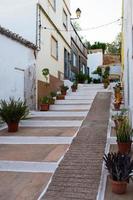 belle rue à alvor. maisons blanches, pots avec des plantes. portimão, algarve, portugal photo