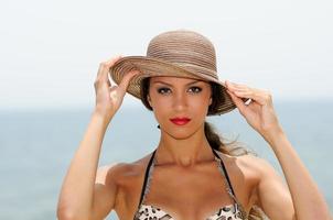 jolie femme avec un chapeau de soleil sur une plage tropicale photo