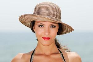 femme avec un chapeau de soleil sur une plage tropicale photo