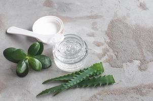 texture gel avec des bulles d'acide hyaluronique et des branches d'aloe vera dans un bocal en verre photo