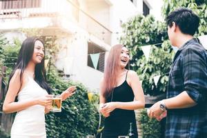 les adolescents profitent d'une garden-party à la maison et tiennent le verre à bière à la main. photo