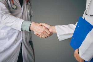 deux médecins se serrant la main en travaillant ensemble. photo