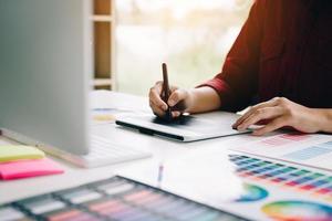 graphiste travaillant avec un numériseur et un ordinateur au bureau. photo