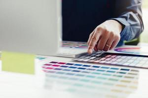 gros plan d'un jeune graphiste choisissant une couleur de la palette dans un bureau moderne. photo