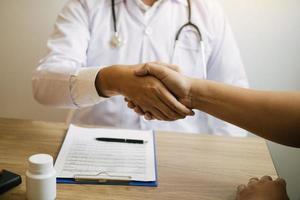 médecin serrant la main d'un patient plus âgé dans la salle de la clinique. photo