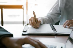 consultant faisant un rapport sommaire de note avec le gestionnaire utilisant un ordinateur portable sur le bureau dans la salle de bureau. photo