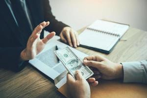 des partenaires commerciaux soumettent de l'argent frauduleux à des entrepreneurs dont les hommes d'affaires refusent d'accepter des pots-de-vin au bureau. photo