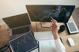 homme investisseur analysant le graphique du marché boursier à l'aide d'un stylo pointant vers l'écran de l'ordinateur. photo