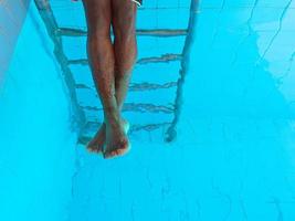 les jambes de l'homme afro-américain adulte sous l'eau dans la piscine photo