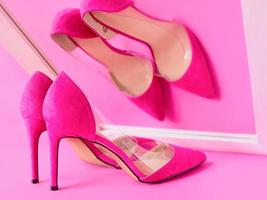 chaussures à talons hauts roses élégantes sur fond rose regardant son propre reflet dans le miroir. chaussures, mode, ego, égoïste, narcissisme, style, shopping, concept de vente photo