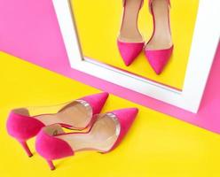 chaussures à talons hauts roses élégantes sur fond rose regardant son propre reflet dans le miroir. chaussures, mode, ego, égoïste, narcissisme, style, shopping, concept de vente photo