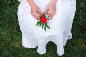 boutonnière pour mariage entre les mains d'une jeune fille mariée en robe blanche. copie, espace vide pour le texte photo