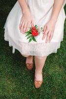 boutonnière pour mariage entre les mains d'une jeune fille mariée en robe blanche. copie, espace vide pour le texte photo