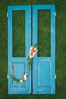 couronne décorée de fleurs, de feuilles et d'herbe sèche sur un fond de porte bleue en bois. copie, espace vide pour le texte photo