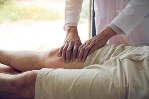 les physiothérapeutes utilisent les mains pour saisir la cuisse du patient pour vérifier la douleur et le massage dans la clinique. photo