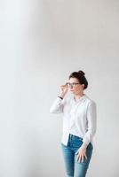 belle femme à lunettes optiques et une chemise blanche sur fond blanc. copie, espace vide pour le texte photo