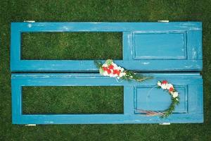 couronne décorée de fleurs, de feuilles et d'herbe sèche sur un fond de porte bleue en bois. copie, espace vide pour le texte photo