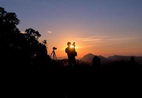 photographe debout au coucher du soleil photo