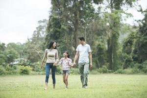 parents heureux et leur fille marchant dans le parc, concept de famille heureuse. photo