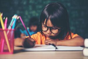 fille avec dessin au crayon à la leçon en classe photo