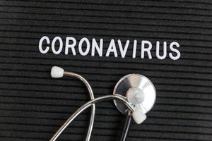 phrase de texte coronavirus et stéthoscope sur fond noir de tableau de lettres. nouveau coronavirus 2019-ncov, mers-cov coronavirus du syndrome respiratoire du moyen-orient originaire de wuhan en chine photo