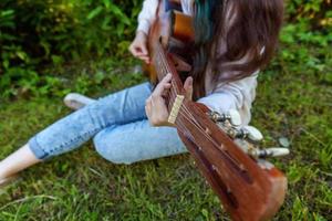 mains de femme jouant de la guitare acoustique photo