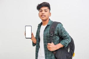 jeune étudiant indien montrant l'écran du smartphone sur fond blanc. photo