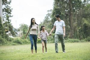 parents heureux et leur fille marchant dans le parc, concept de famille heureuse. photo