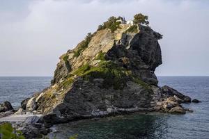 présentée dans la comédie musicale à succès "mama mia", la chapelle de saint jean le baptiste se dresse de façon spectaculaire au sommet d'un doigt de roche au large de l'île de skopelos dans la mer égée en grèce. photo