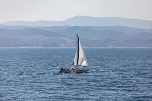 un seul voilier blanc en pleine mer. photo