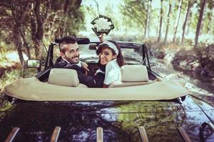 couple juste marié dans une vieille voiture photo