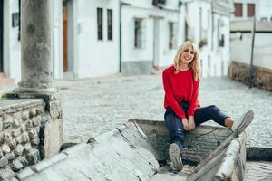 fille blonde souriante avec une chemise rouge profitant de la vie à l'extérieur. photo