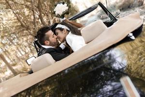 couple juste marié dans une vieille voiture photo