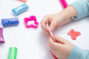 les mains des enfants jouent de la pâte pour la créativité des enfants. jeu de société pour le développement de la motricité fine photo