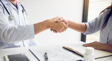 médecin serrant la main d'un patient plus âgé dans la salle de la clinique. photo