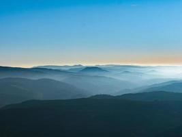 neige blanche et ciel bleu. vue panoramique sur les silhouettes des montagnes. photo