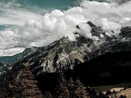 de terribles rochers sans vie, un glacier dans les alpes, des nuages et du brouillard répandus sur les sommets des montagnes photo