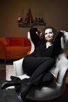 belle jeune fille posant dans un fauteuil blanc chic photo