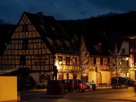 des fenêtres chaleureuses et chaleureuses dans un petit village alsacien. confort et chaleur à la maison un soir d'hiver. photo